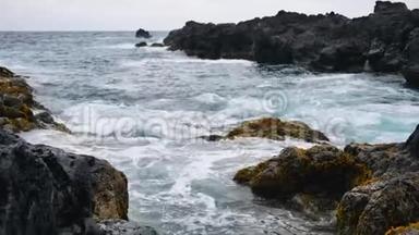 在<strong>汹涌</strong>的浪潮中，岩石海岸上强烈的<strong>海浪</strong>和泡沫