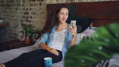 漂亮的女人在网上和朋友聊天，用智能手机打视频电话，她很高兴，也很兴奋。 年轻女士