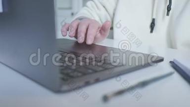 女商人`手触摸笔记本电脑`触摸板。 女人`手在滚动图片。 女人在用笔记本电脑。 女人席
