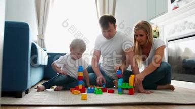 幸福的家庭<strong>爸爸妈妈</strong>和宝宝在他们明亮的客厅里玩乐高。 慢镜头拍摄幸福家庭