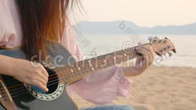 4K. 在日落时分，她在沙滩上用轻柔的风弹着吉他，感到放松