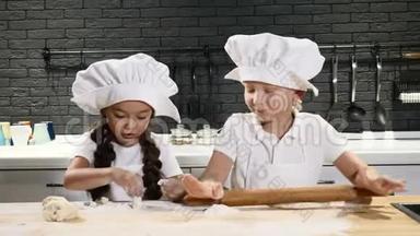 厨师<strong>小子</strong>。 两个孩子玩厨房。 穿着厨师帽和围裙的小男孩和学龄前男孩为生日做蛋糕