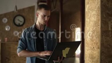 迷人的集中精力的年轻商人手里拿着一台笔记本电脑走路，打字。 高加索人在
