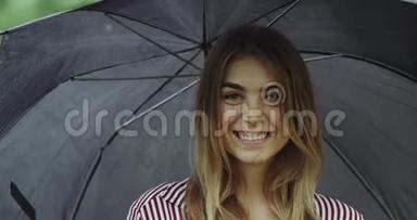 伞下一个美丽的微笑女孩的肖像特写。