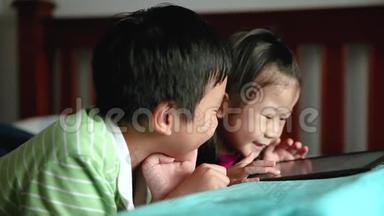 亚洲儿童使用数字平板电脑。 电子学习概念。
