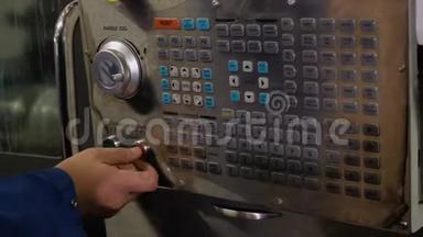 机器操作员按下遥控器上的控制按钮。 带有数控的机器。