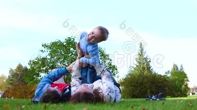 幸福的家庭躺在草坪上。 母亲和父亲抱着儿子抱在怀里抱着他的头，孩子笑了。 关于