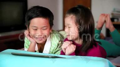 亚洲儿童使用数字平板电脑。 电子学习概念。