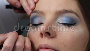 化妆师将黑色眼线应用于模型眼。 全高清