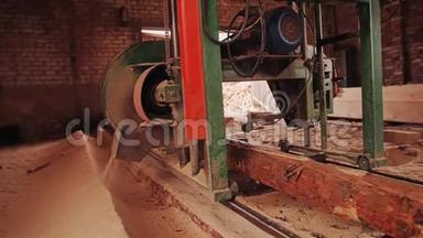 板上锯<strong>原木</strong>的机器沿着<strong>原木</strong>移动。 在锯木厂工作。