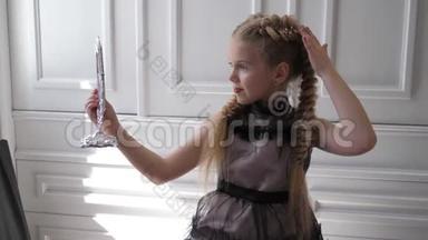 时尚的小女孩，漂亮的发型和时尚的化妆，在背景<strong>白墙</strong>上照镜子