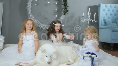 神奇的新年，孩子们穿着白色连衣裙和人造雪在工作室与宠物的冬季摄影。