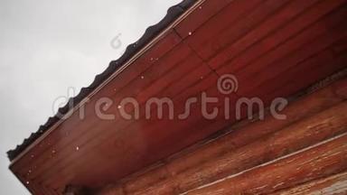 雨水带着一个木屋顶美丽地流下来。 不同的季节。