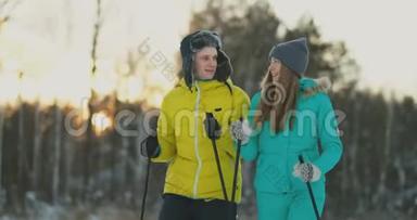 一对活跃的年轻夫妇在白雪皑皑的冬林中享受滑雪的完整肖像，集中在微笑的女人面前