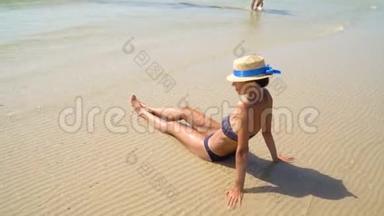 <strong>夏季</strong>生活方式高清视频漂亮年轻晒黑的女人戴帽子。 享受生活，坐在海滩上，时间到了