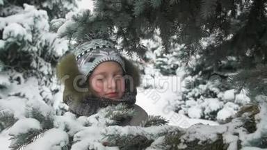 不开心的小女孩站在冷杉树下摆姿势，冬日的森林，雪景的冷杉树