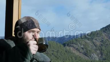 站在<strong>观景台</strong>上看山、喝大杯咖啡或茶的长胡子的孤独男子。4公里