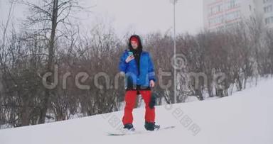 在滑<strong>雪坡</strong>滑雪时，使用智能手机拍摄风景图片