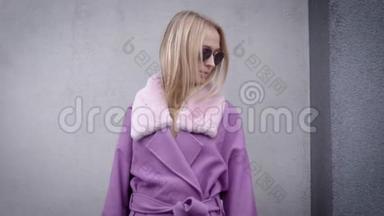一个穿着<strong>紫色外套</strong>和太阳镜的迷人金发女孩的肖像，寒冷的秋天天气。