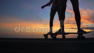 两个穿着短裤和运动鞋的女朋友在山坡上踩着美丽的滑板，腿上的特写