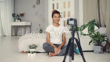 漂亮的非裔美国女孩<strong>创意</strong>博客作者正在录制关于坐在公寓<strong>地板</strong>上的植物的视频