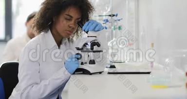 美国黑人女科学家在现代实验室做显微镜分析
