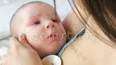 一位美丽的<strong>年轻</strong>长发母亲轻轻地抚摸着她新生的婴儿，抱在怀里，坐在床上。 这<strong>就是</strong>