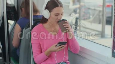 坐在公共交通工具上享受旅行的年轻女乘客，戴着耳机坐在现代有轨电车的车窗旁。