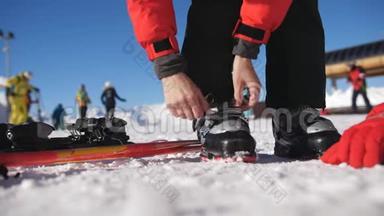 在一个阳光明媚的早晨，滑雪者穿着滑雪靴走进滑雪板。 修理滑雪靴. 近距离滑雪。