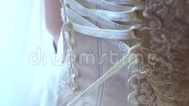 婚纱特写.. 伴娘用蝴蝶结向婚纱鞠躬。 新娘正在准备婚礼。 球球