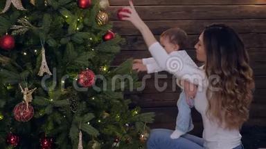 家庭主妇，年轻的母亲和女儿一起在<strong>圣诞夜</strong>的房间装饰新年树