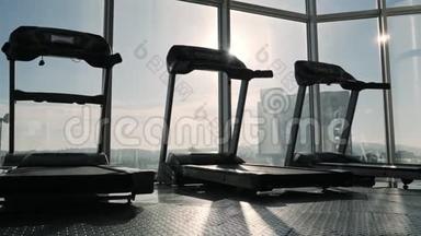 大窗户附近运动健身房跑步机的视野。