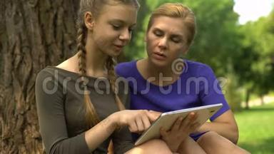 妈妈和女儿在平板电脑上<strong>复习</strong>大学课程申请，在线服务