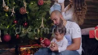 家庭装饰圣诞树，两个小女孩在<strong>圣诞夜</strong>和爸爸妈妈在一起
