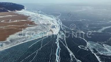 从上面拍摄的美丽的深蓝冰纹理的<strong>贝</strong>加尔湖表面和海岸空中透视