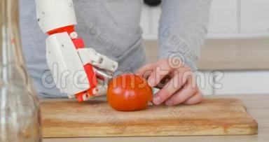 机器人假肢手上有刀的人正在木板上切割番茄。 肌肉再神经技术..
