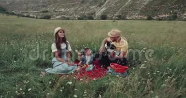和一家人<strong>一起去</strong>野餐，在大自然的中间，人们在弹吉他