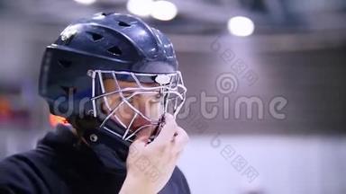 疲惫的曲棍球运动员在打冰球时摘下面具
