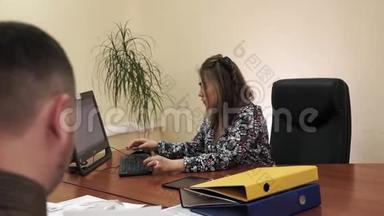年轻的女商<strong>人坐</strong>在办公室的办公桌<strong>前</strong>，在<strong>电脑</strong>上工作