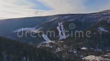 空中无人机在背景冬季的山村景色。 雪天美丽的山