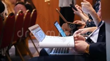 商业概念。 人们坐在笔记本电脑旁，一边做笔记讲课
