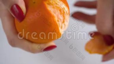 女人`手剥橘子皮，橘子片堆在盘子里