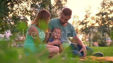 夏天，<strong>一家人</strong>坐在公园的地毯上，<strong>女儿</strong>在玩耍，放松观念