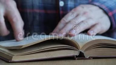 一个人用俄语<strong>翻阅</strong>一本书，用手指<strong>翻阅</strong>书页，研究书页