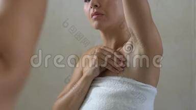 不高兴的女人检查腋窝处的皮肤，不良的脱毛，刺激和皱纹