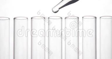 移液管将清洁的化学物质滴入白底一排中间的试管中。化学和医学概念。