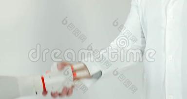 机器人假体手和白色背景上白色外套的人手握手。