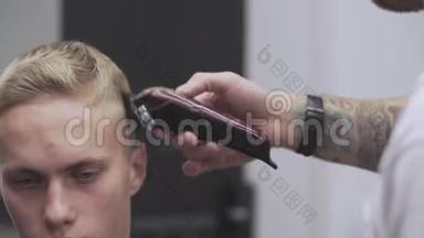 男人用电动剃须刀理发。 用电动修边器在慢模中定型