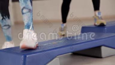 阶梯平台。 穿运动鞋的女孩做<strong>健身操</strong>。 健身房减肥的概念