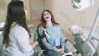 慢镜头拍摄女孩躺在牙科椅上，微笑着。 一位女医生打算用一种现代的方法钻她<strong>疼痛</strong>的<strong>牙齿</strong>